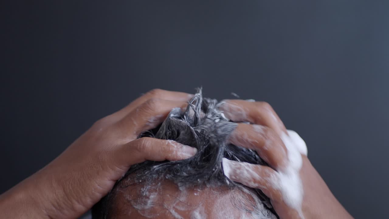 Uomo che si lava i capelli con lo shampoo