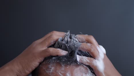 hombre lavándose el cabello con champú