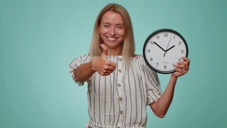 encantadora mujer joven mostrando la hora en el reloj, ok, pulgar arriba, aprobar, señalando con el dedo a la cámara