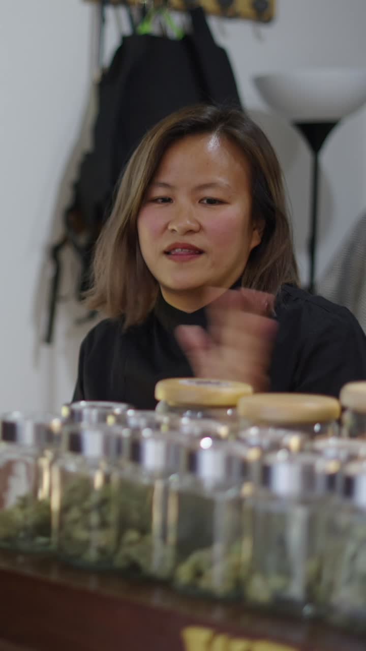 Woman in shop with cannabis in jars