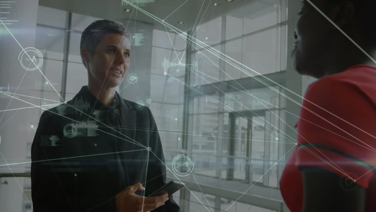 animación de una red de conexiones contra dos mujeres de negocios diversas discutiendo en la oficina.