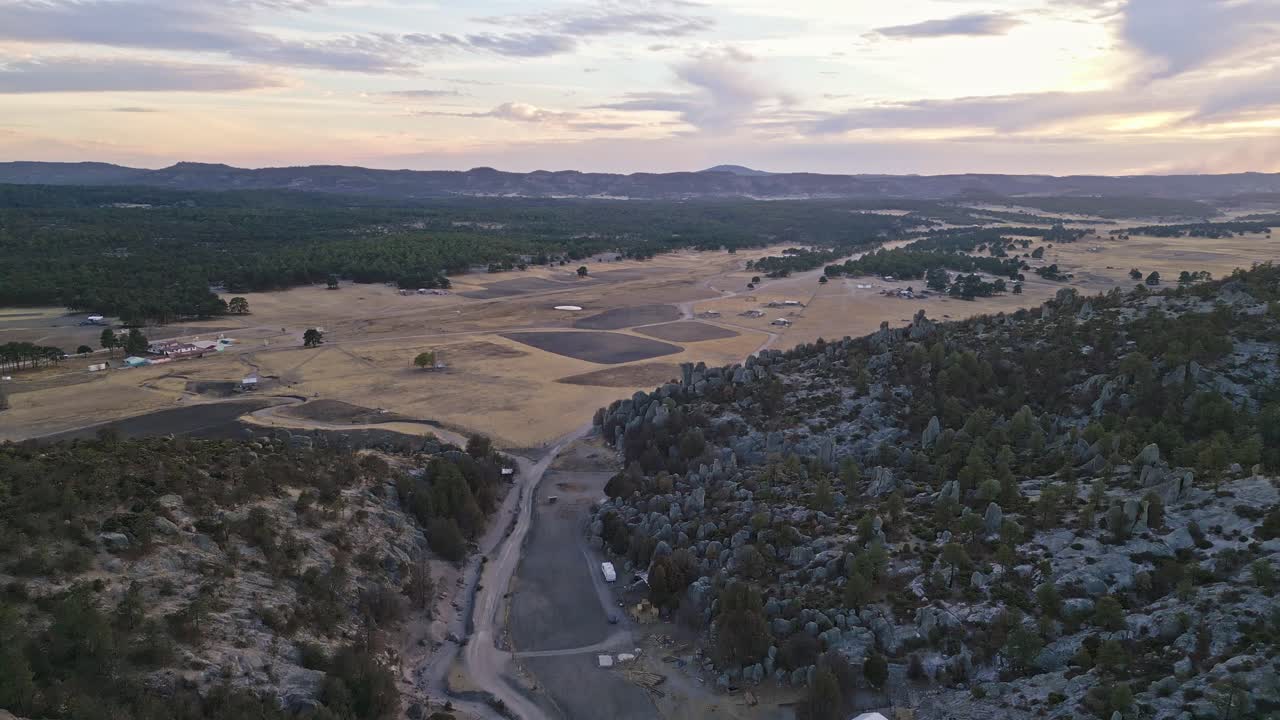 Expansive aerial view of vast rocky terrain with forested hills in Valle de los Monjes, Chihuahua