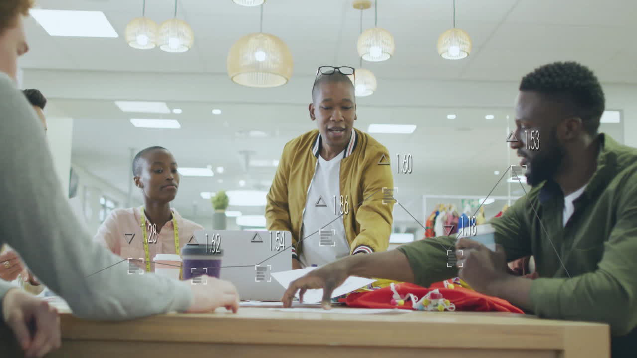 Diverse team collaborating at office table with data processing animation overlay