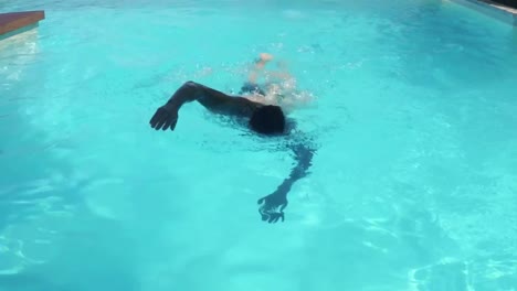hombre guapo nadando en la piscina