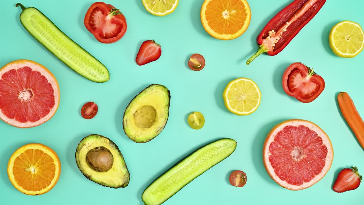 haciendo un patrón creativo con frutas frescas maduras en rodajas sobre un fondo cian.