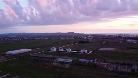 aerial above majestic landscape with modern apartment buildings and farms in albania.