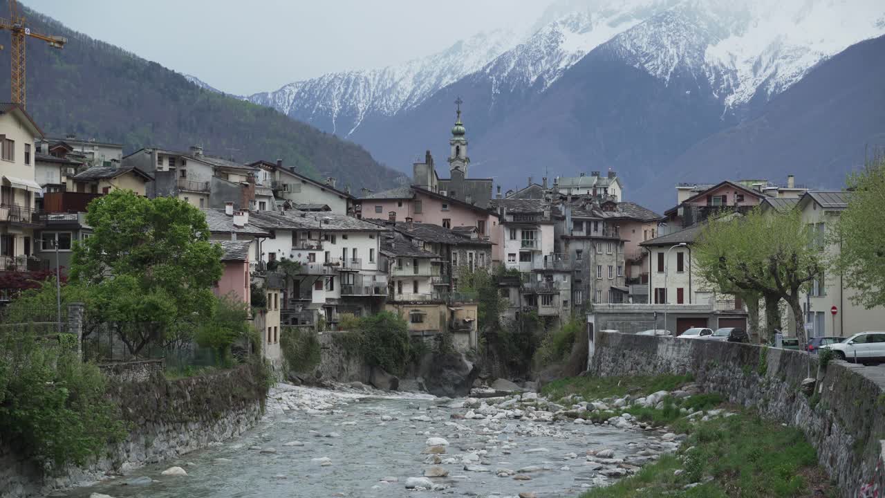 glimpse of the town of Chiavenna above the river, mountains in the background