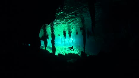 scuba divers below cenote swimmers