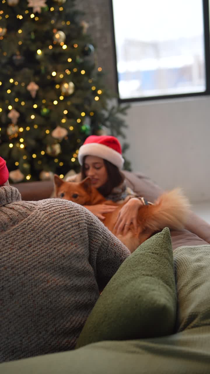 una pareja con un perro en navidad.