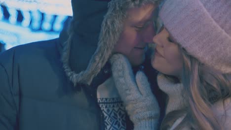 positive man and woman hug at winter fair in evening