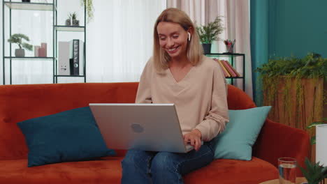 Woman-sitting-on-home-couch,-looking-at-camera,-making-video-conference-call-with-friends-or-family