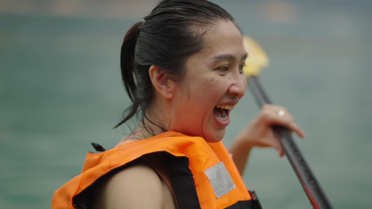 Happy woman enjoying kayaking on the water