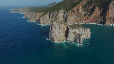 aerial view in orbit and in the middle distance of pan di zucchero on the island of sardinia, near masua