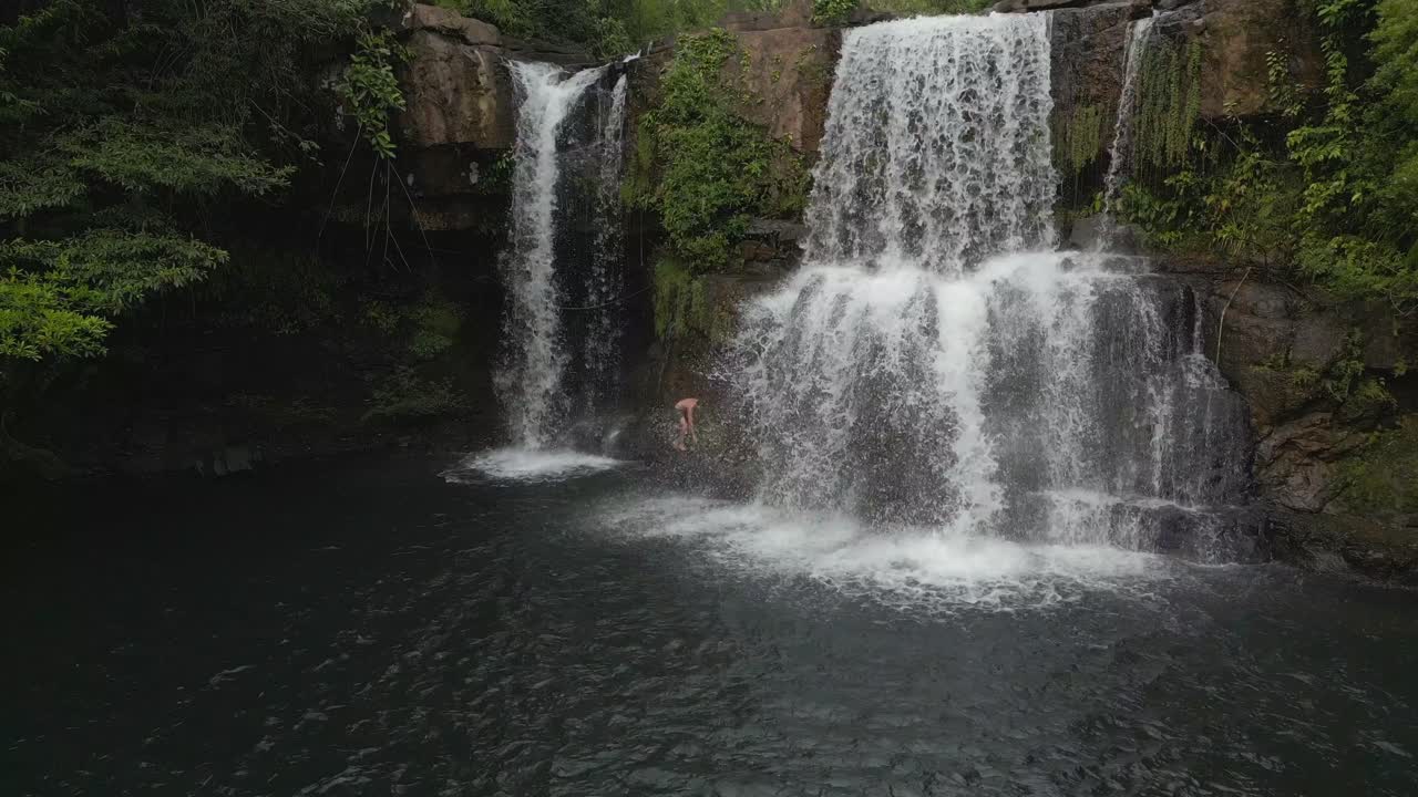 hombre indígena escalando cascada en la jungla
