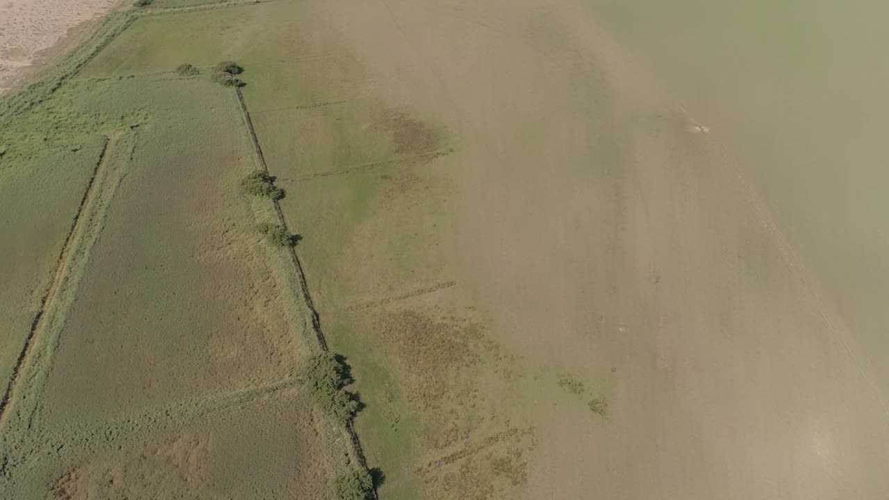 vista aérea desde arriba sobre una laguna avanza y se eleva para revelar la playa de chesil, dorset