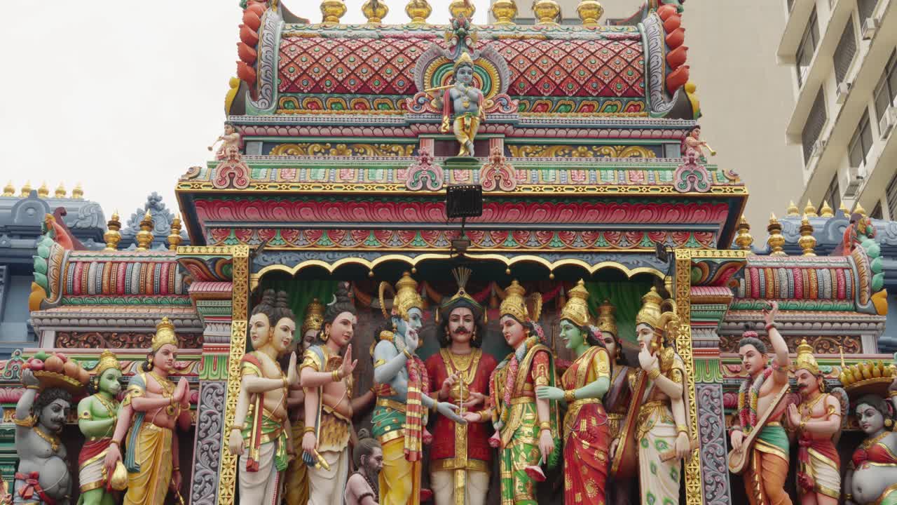 Detailed carvings of Hindu deities on a colorful temple facade