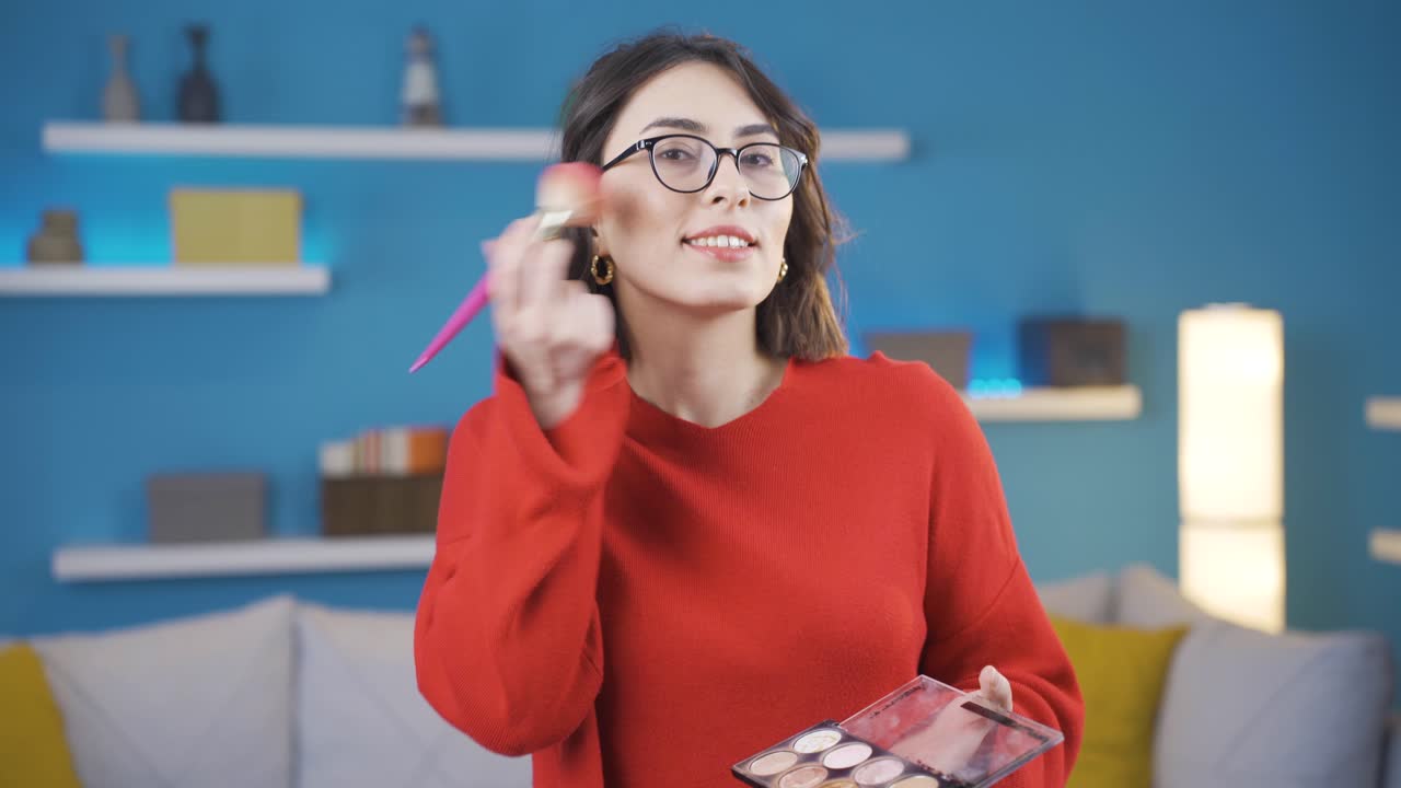 mujer joven feliz haciendo maquillaje mirando a la cámara.