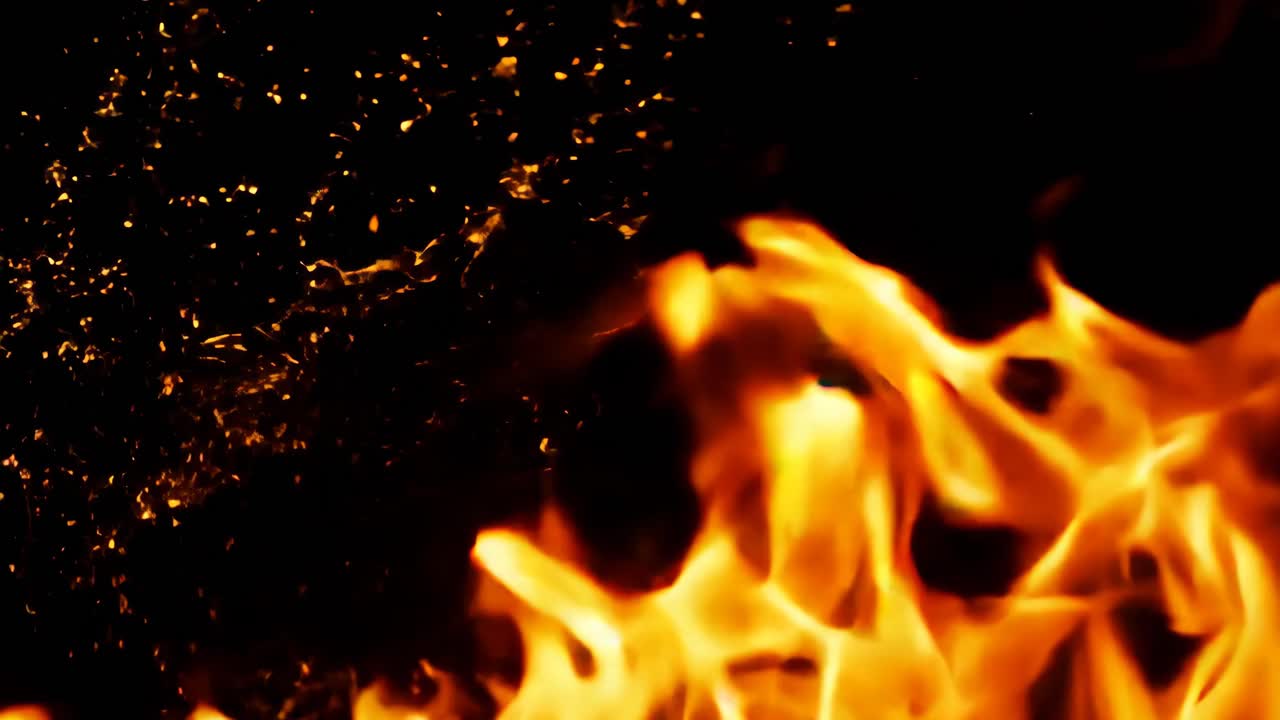 A close up of a fire with a lot of smoke and ash. The fire is orange and yellow, and the smoke is dark and billowing. Scene is intense and dramatic