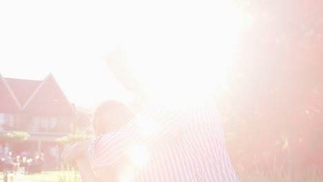 Grandmother-Playing-Game-And-Dancing-With-Granddaughter-In-Garden-Of-Summer-Pub