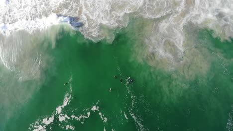 Descripción-General-De-Imágenes-De-Drones-De-Bodyboarders-Y-Surfistas-En-El-Agua,-Mar-Con-Olas-Rodando