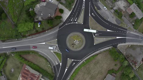 aerial view of cars passing a roundabout, shooting from a drone in rotation