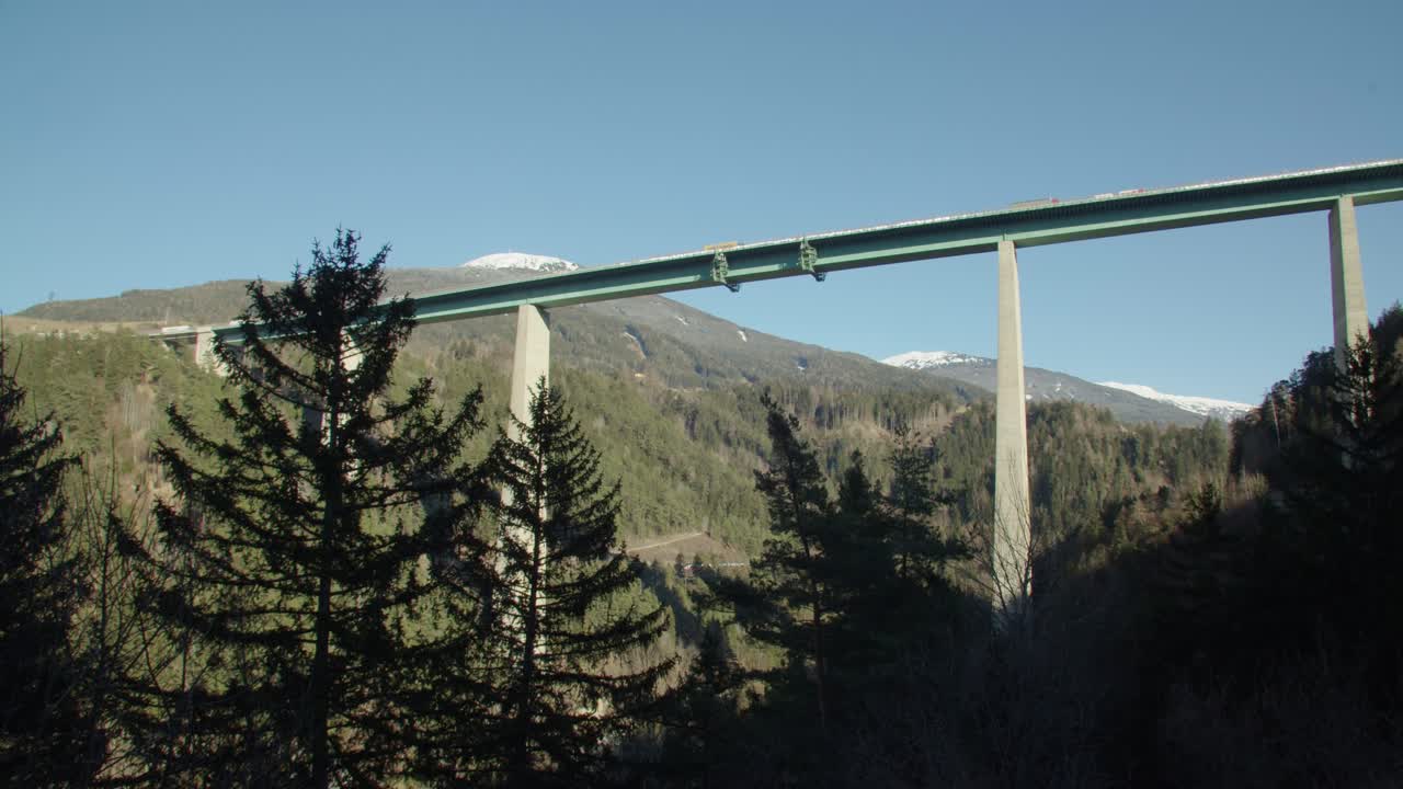 Long, tall Brenner bridge stretching across wooded alpine landscape.