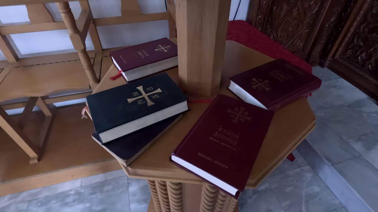 Diversi libri sono disposti su un altare in una chiesa. L'area è circondata da mobili in legno. L'atmosfera suggerisce uno spazio per la lettura e la riflessione durante le funzioni religiose.