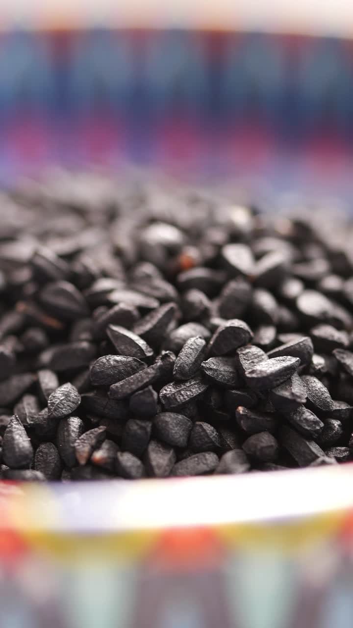 Close-up of Black Nigella Seeds in a Colorful Bowl