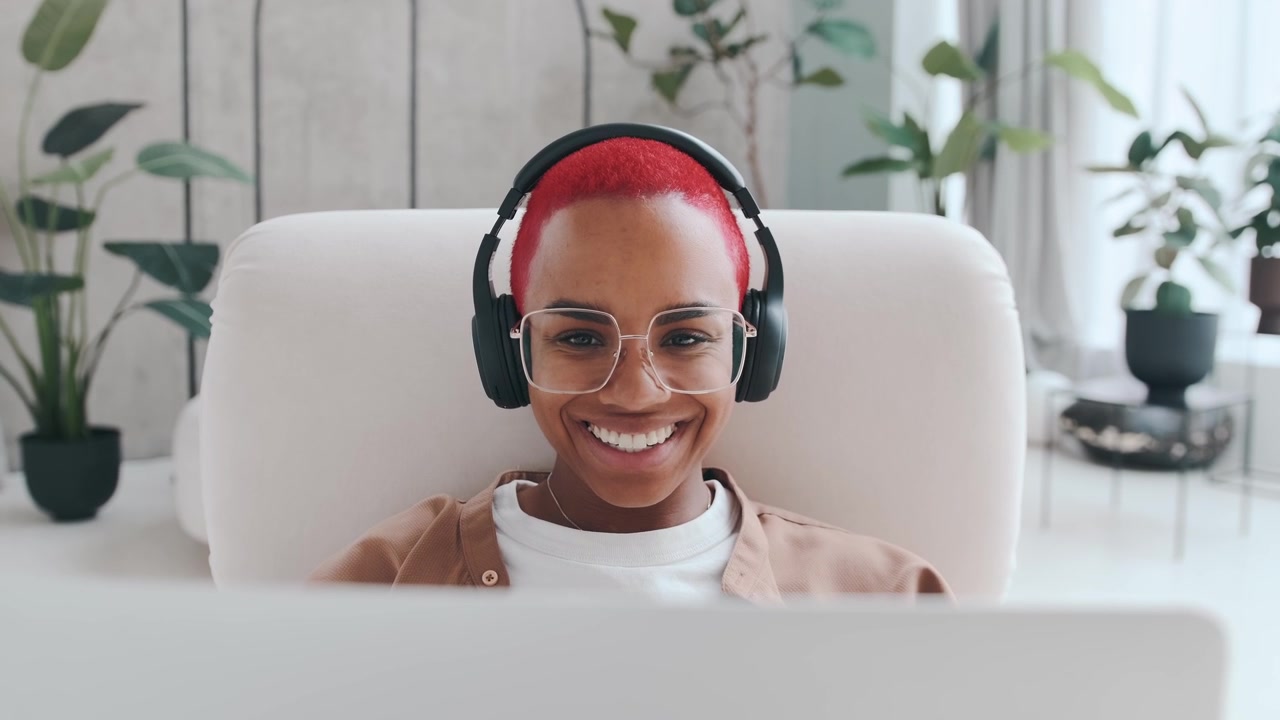 Young african american woman makes video call on laptop sits in chair