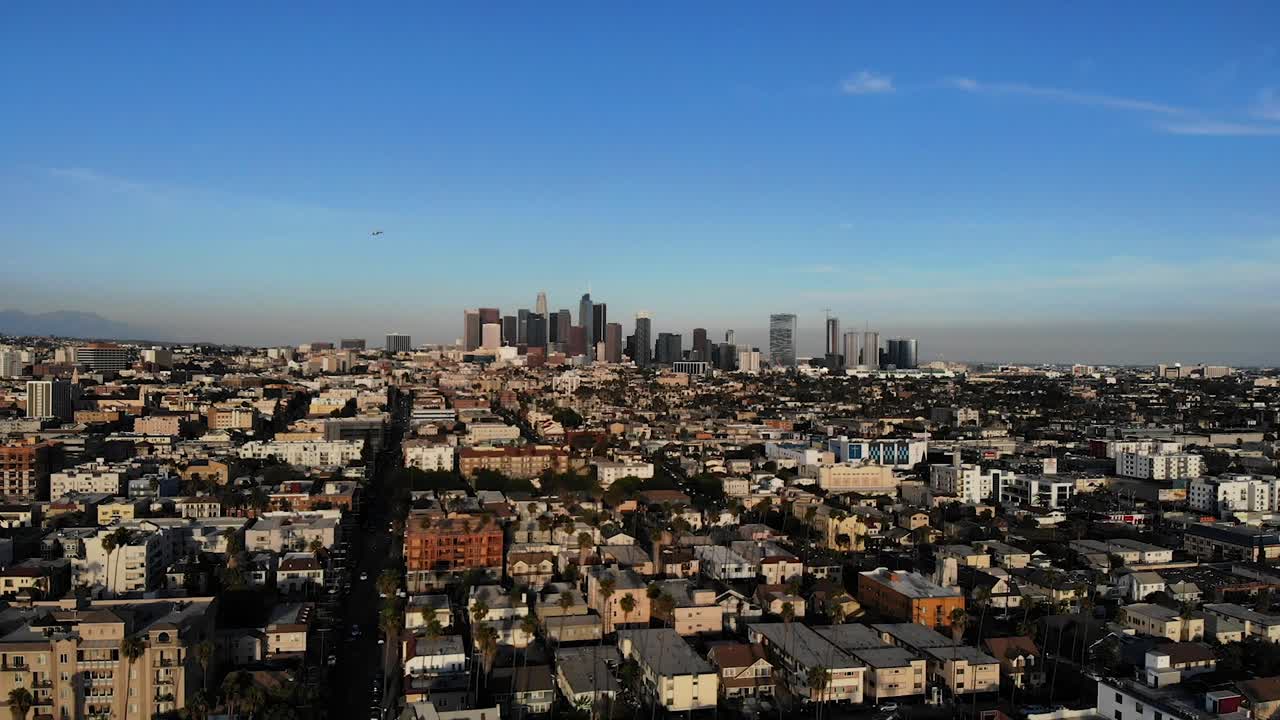 A drone shot flying through the air of downtown Los Angeles at sunset.