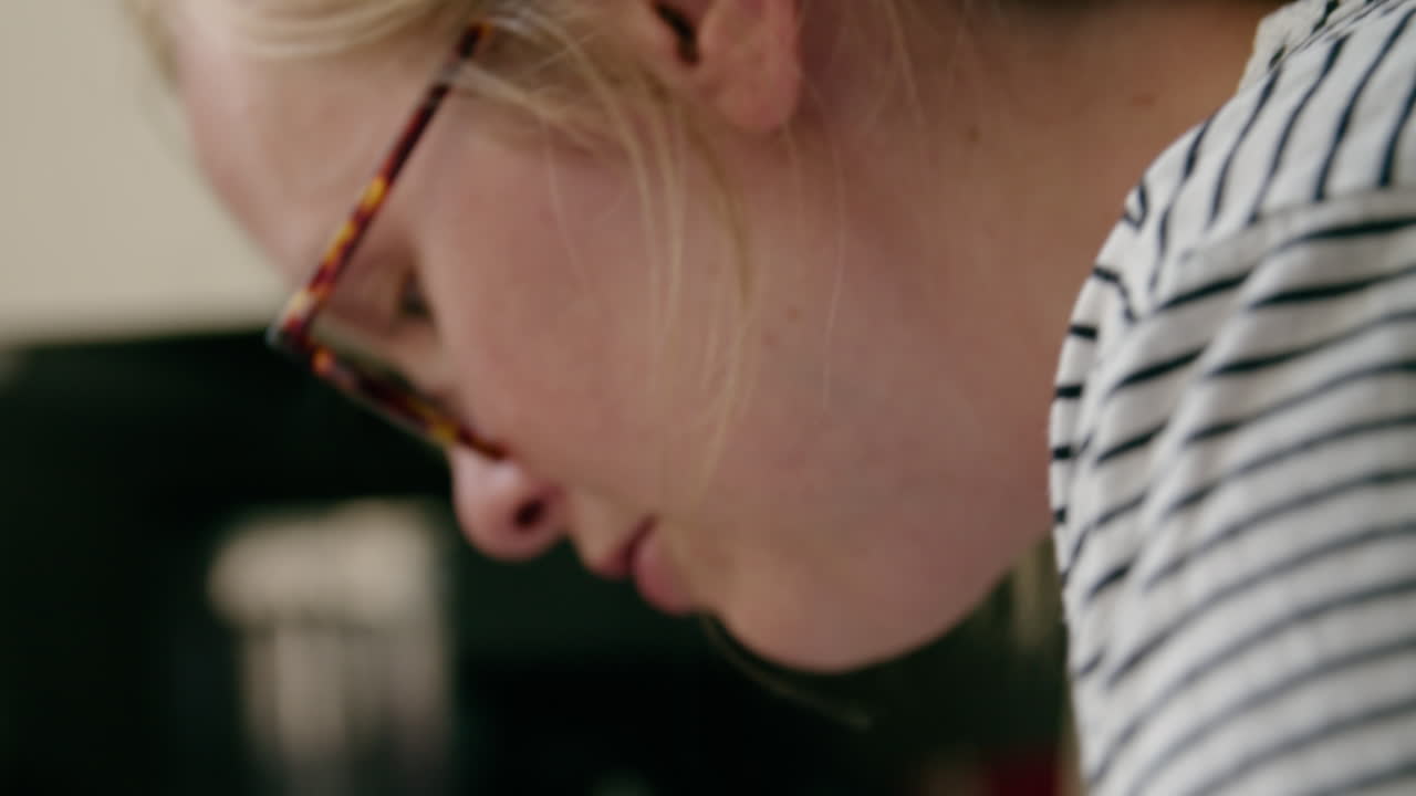 젊은 어머니는 부엌 싱크대에서 아기를 목욕시키면서 미소 짓는다