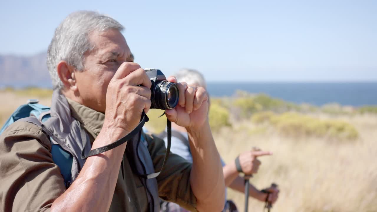 una feliz pareja biracial senior que pasa tiempo juntos en las montañas haciendo senderismo