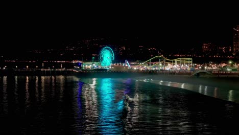 beautiful aerial drone shot of the santa monica pier at night in the dark