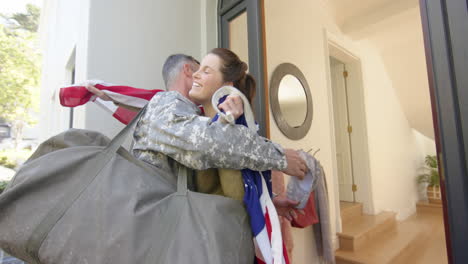 happy caucasian woman with flag welcoming home male soldier