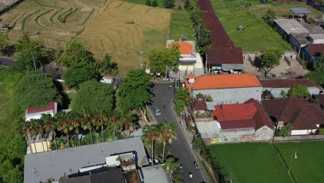 aerial top down zoom in of traffic approaching a fork in the road intersection in bali indonesia