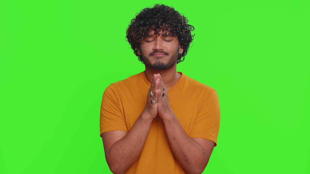 Indian handsome man praying looking upward making wish begging apology asking help forgive me