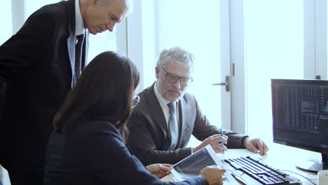 confident female finance professional explaining charts to teammates