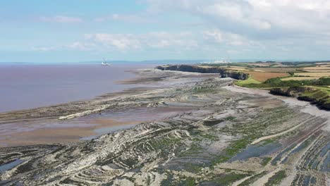 drone shot while rising up over kilve beach and its sea cliffs in north devon, uk