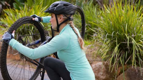 female cyclist repairing bicycle tyre