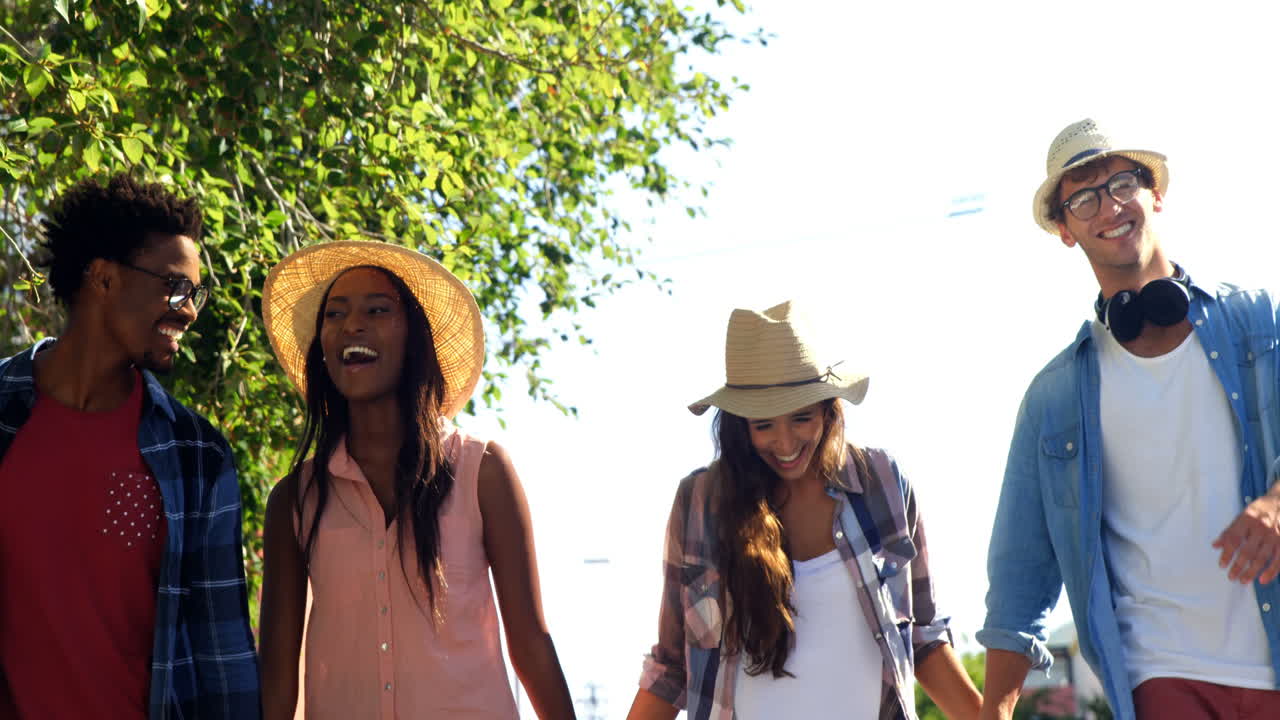 Hipsters are holding by hand and walking in the street 