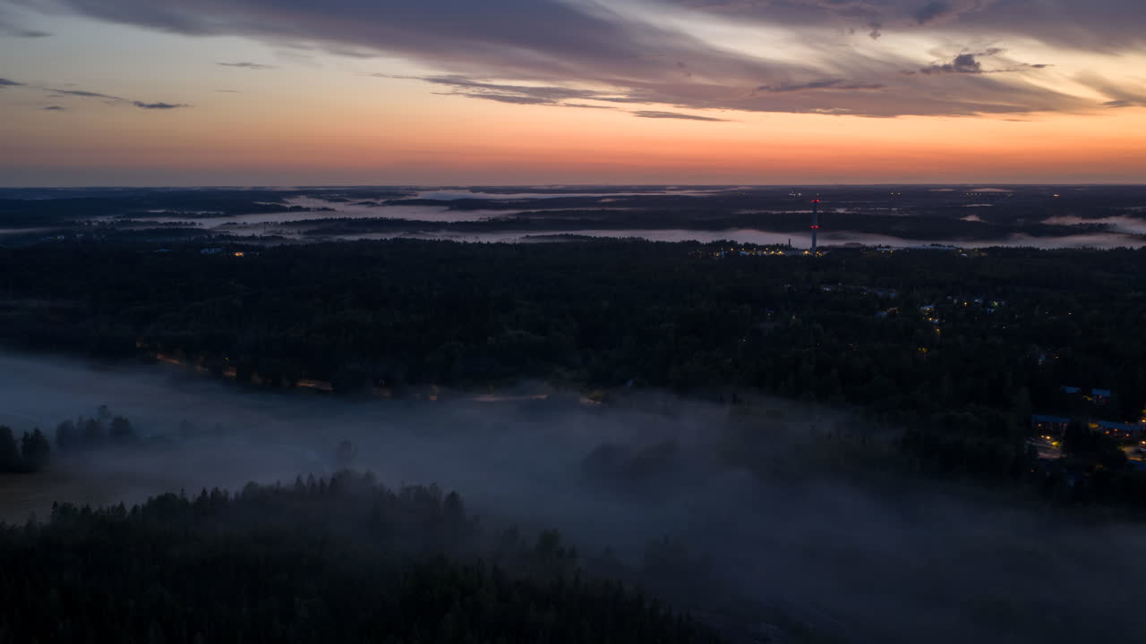 Hyperlapse drone shot of morning fog above trains and residential areas of Espoo