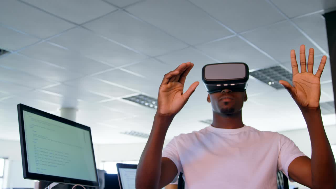 Junge schwarze männliche Führungskraft nutzt Virtual-Reality-Headset am Schreibtisch im modernen Büro 4k
