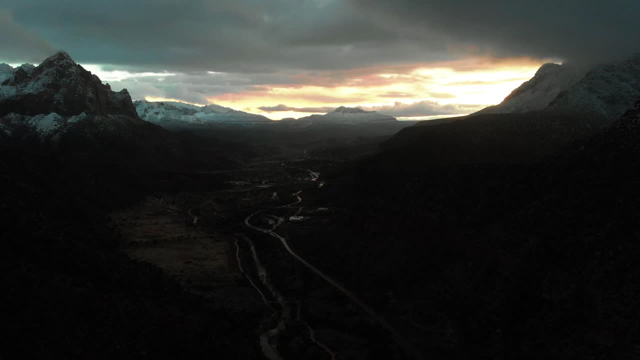Stunning aerial shot of the snow covered mountains in Zion National Park during sunset on a cloudy day.