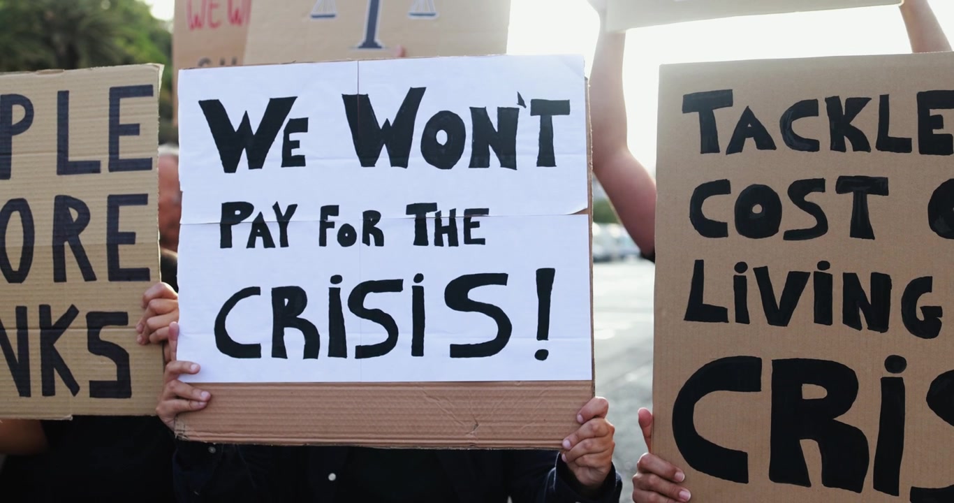 Manifestanti con cartelli che chiedono interventi sulla crisi economica