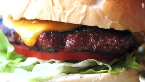 close up of a cheeseburger with lettuce, tomato, and cheese