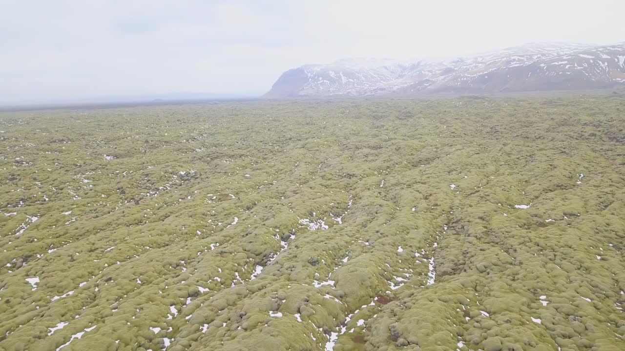 Aerial shot panning over beautiful green Icelandic terrain