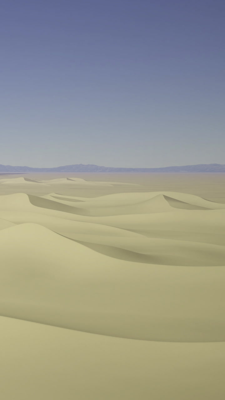 Expansive sands roll like waves under the clear blue sky