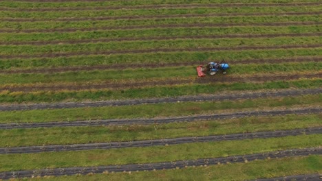 flying over a tractor farming in an agricultural field