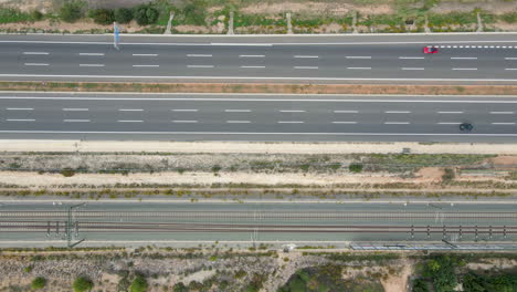 Vista-Aérea-De-La-Autovía-Valencia-Madrid-Con-Coches-Circulando-En-Direcciones-Opuestas-Junto-A-Las-Vías-Del-Tren-Ave-Renfe