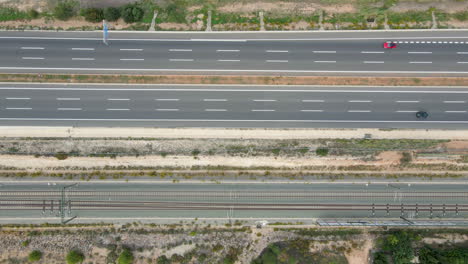 vista aérea de la autopista valencia-madrid con coches que viajan en direcciones opuestas junto a las vías del tren de la avenida renfe
